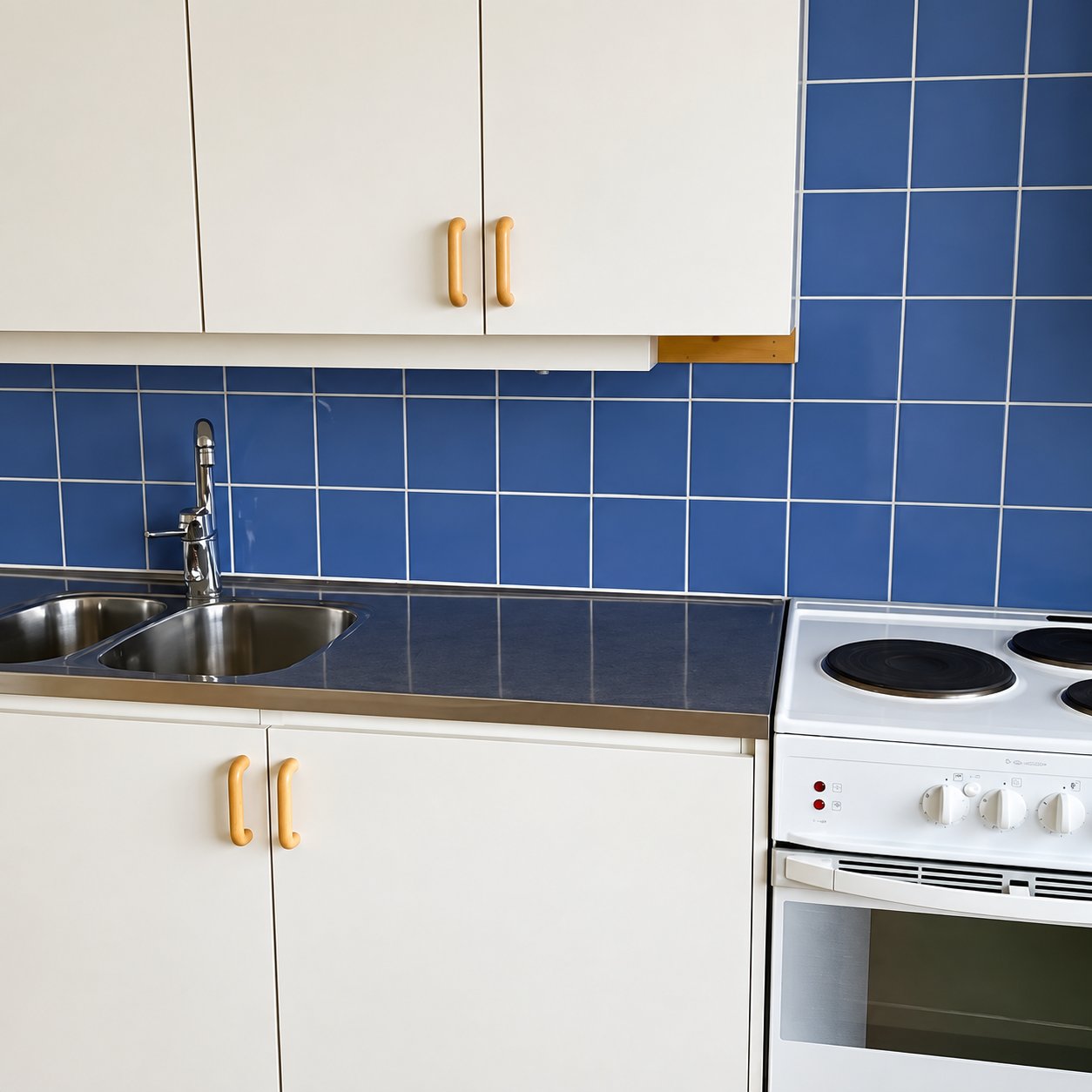 Rent kök med blått kakel och rostfritt handfat